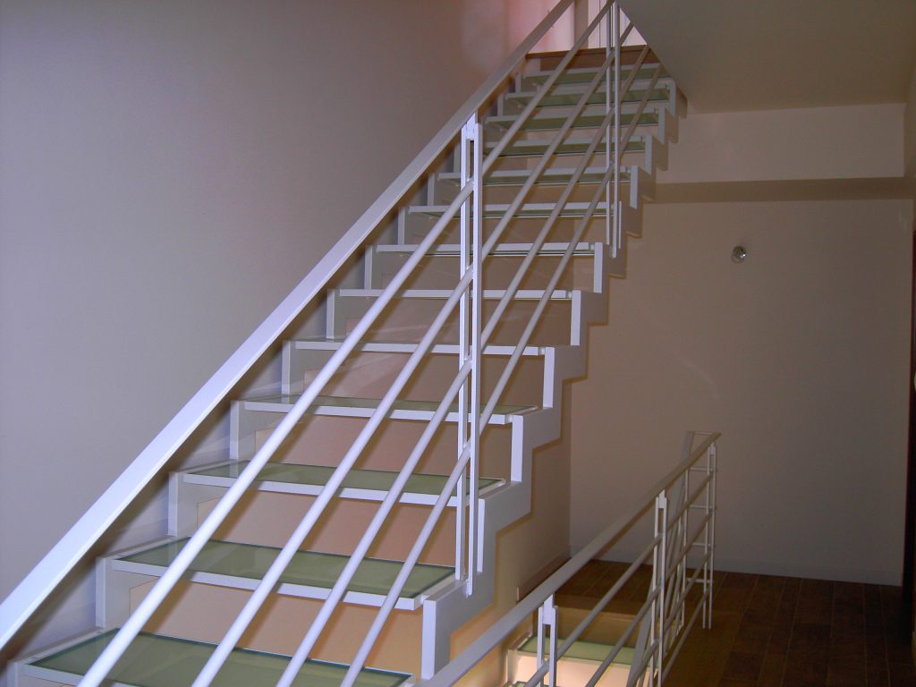 Scala interna in acciaio verniciato bianco con pedate in vetro e parapetto a correnti orizzontali, realizzata da SAIME
